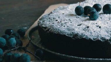 Çikolatalı kek kek cömertçe şık yanındaki mavi çilek yalan pudra şekeri ile kaplı.