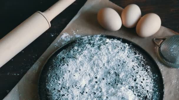 Muffin casero del brownie del chocolate horneado en polvo con el azúcar contra un fondo de huevos y del perno rodante de madera — Vídeos de Stock