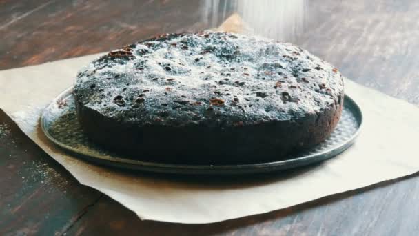 Pó de bolo de brownie de chocolate muito grande em cima com açúcar de confeiteiro branco — Vídeo de Stock