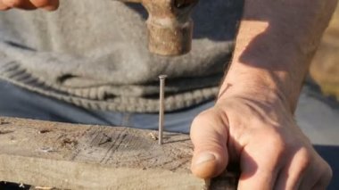 Erkek marangoz ahşap bir tahta demir çivi çekiç