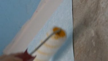 Mavi yetkin duvar kağıdı saçtan yakından özel inşaat silindiri ile duvara yapıştırılmış