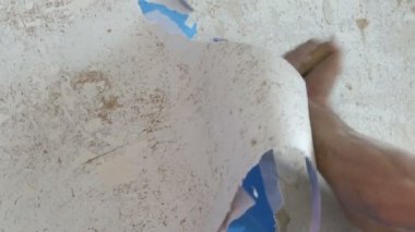 Adam temizler ve duvar kağıdı eski duvardan peeling