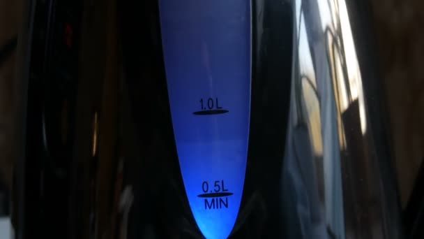 Elegante pantalla azul en una tetera negra. Hervir el agua en la tetera eléctrica — Vídeos de Stock
