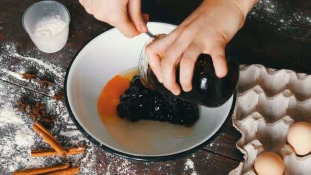 Frauenhände geben Eier, Marmelade, Mehl in ein Gefäß und vermischen es mit einem Schneebesen. Teig für Kirschtorte. hausgemachtes Backen — Stockvideo