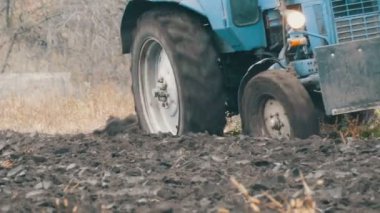 Mavi traktör ile siyah toprakla tarlayı dört karık plough görünümü kapatın