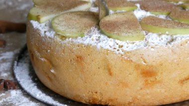 Bıçak lezzetli taze pişmiş yemyeşil elmalı turta charlotte görünümü kadar yeşil elma yakın bir arka plan üzerine bir parça sunmaktadır. Geleneksel ev yapımı elma tarçın pasta