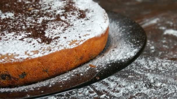 Delicioso delicioso pastel de cereza recién horneado hecho en casa con azúcar en polvo y chispas de chocolate en un elegante plato negro — Vídeos de Stock