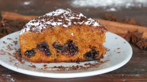 Delicioso pedazo de pastel de cereza recién horneado casero con azúcar en polvo y chispas de chocolate en platillo blanco — Vídeos de Stock