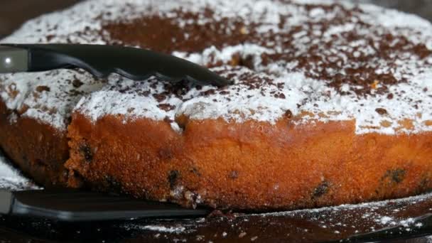 キッチンはさみは、粉砂糖とすりおろしたチョコレート チップでおいしい焼きたてチェリーパイのスライスを取る。手作りのパン — ストック動画