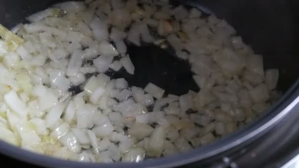 Stekt hackad lök i het kokande olja. Närbild av stekpannan. Matlagning grönsaker — Stockvideo