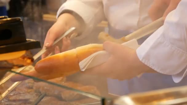 Hombre vendedor hace un enorme hot dog en el mercado de Navidad de la calle nacional de comida alemana — Vídeos de Stock