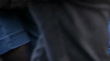 Beyaz köpek mavi bir battaniye ile örtülü evsiz kişinin görünümü kadar yakın sokakta yatıyor. Bir peçe ile kaplı bir sokak köpeği bir şehir sokakta yatıyor, insanların kalabalıklar tarafından yürümek.