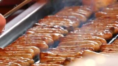 Kadınlar çok lezzetli taze Alman sosis ızgara. Nürnberg sosis taze çörek yakınındaki çok sayıda gıda pazarına yakın görünümü Noel hazırlanır