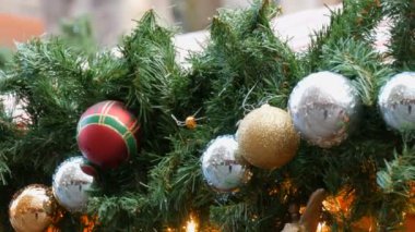 O asmak bir sokakta bir köknar çelenk ve kırmızı altın ve gümüş Noel ile şeklinde Noel ve yılbaşı dekorasyonu topları ve geçen insanlar yansıttıkları