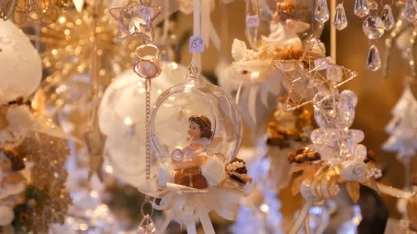 Belle delicate decorazioni di giocattoli di Natale sottili in vetro e porcellana sotto forma di angeli ondeggiano su una finestra del mercatino di Natale in Germania. Felice anno nuovo — Video Stock