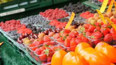 Tatlı kiraz, çilek, çeşitli meyveler ile açık piyasa üzerinde yaban mersini Trabzon hurması vitrin. Meyve ve çilek. Doğal vitaminler