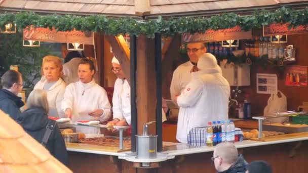 Nürnberg, Tyskland - 1 December 2018: Kiosk på Europeiska julmarknad, som säljer nationella tyska korvar. Skara människor queuing för mat — Stockvideo