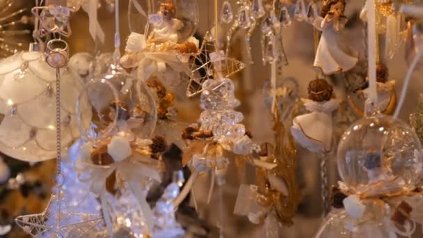 Hermosas delicadas decoraciones sutiles de juguete de Navidad hechas de vidrio y porcelana en forma de ángeles influir en una ventana del mercado de Navidad en Alemania. Feliz año nuevo — Vídeo de stock