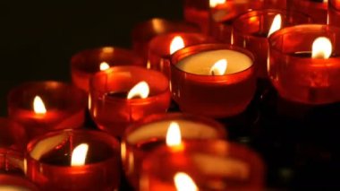 Satır Hıristiyan dua kırmızı yuvarlak Adak mumları yanık içinde belgili tanımlık karanlık. Kurban mum dua görünümü kapatın. Katolik Kilisesi içinde yanan memorial mumlar. Katedralde Noel kutlamaları