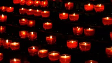 Satır Hıristiyan dua kırmızı yuvarlak Adak mumları yanık içinde belgili tanımlık karanlık. Kurban mum dua. Yanan memorial mumlar Katolik Kilisesi. Katedralde Noel kutlamaları