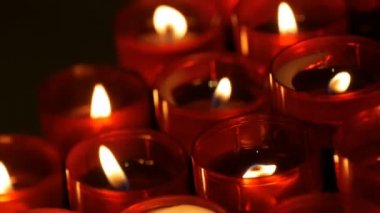 Satır Hıristiyan dua kırmızı yuvarlak Adak mumları yanık içinde belgili tanımlık karanlık. Kurban mum dua kapatın. Katolik Kilisesi içinde yanan memorial mumlar. Katedralde Noel kutlamaları