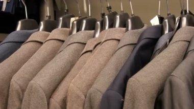 Bir satır bir askı bir erkek giyim mağazasında alışveriş merkezi üzerinde sıcak erkek ceket. Çeşitli mens uygun alışveriş merkezinde asılı