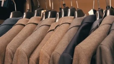 Bir satır bir askı bir erkek giyim mağazasında alışveriş merkezi üzerinde sıcak erkek ceket. Çeşitli mens uygun alışveriş merkezinde asılı