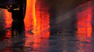 Arabalar trafikte, farlardan asfalt, yağmur altında görüntüleyin. Yağmur su birikintileri geceleri vurur. Arabalar ışıkların yansıması