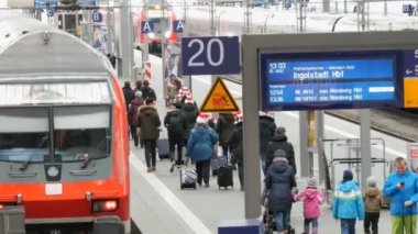 Münih, Almanya - 2 Aralık 2018: Turist yolcu yürüyüş boyunca modern kırmızı tren komik Noel şapka ana tren istasyonunun yanındaki platformu