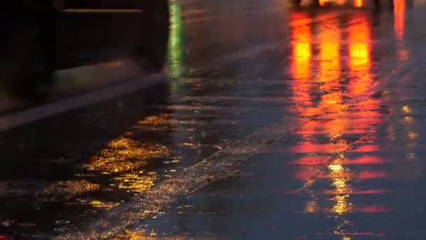 Voitures dans la circulation, phares sous la pluie sur asphalte, vue ci-dessous. La pluie frappe les flaques la nuit. Réflexion des feux de voitures — Video