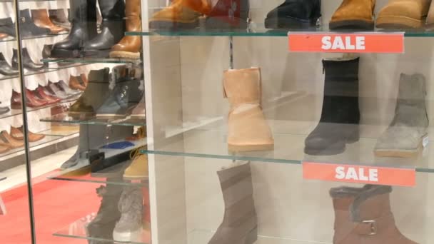 Glasvitrine Schuhgeschäft, auf dem die Beschriftung Verkauf. stylische Herbst-Winter-Schuhe auf der Theke des teuren Ladens. Verschiedene Mode Stiefel mit Rabatt — Stockvideo