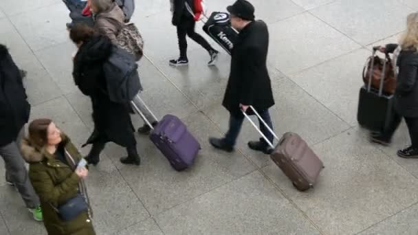 München - 2. Dezember 2018: Blick von oben auf Reisende mit Koffern, Rucksäcken und Taschen, die auf dem Bahnhof unterwegs sind — Stockvideo