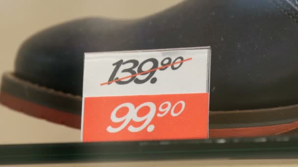 Bottes de luxe en cuir chères dans le magasin de vitrine de chaussures à côté de l'étiquette de prix discount vue rapprochée — Video