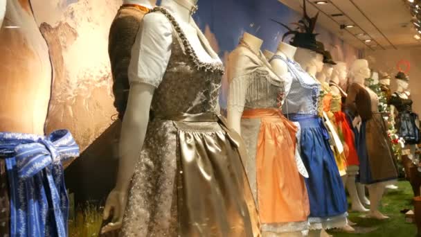 Belas várias mulheres trajes bávaros nacionais dirndl e mens lederhosen na vitrine da loja — Vídeo de Stock