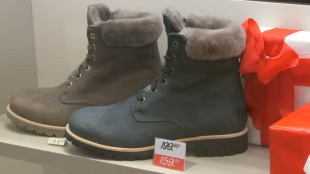 München, Deutschland - 2. Dezember 2018: Teure Luxusstiefel im Schuhgeschäft neben dem Discount-Preisschild Großaufnahme — Stockvideo