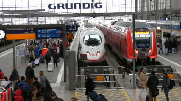 Мюнхен, Германия - 2 декабря 2018: Высокоскоростной и современный поезд стоит на пути. Пассажиры проходят вдоль платформы на железнодорожном вокзале — стоковое видео