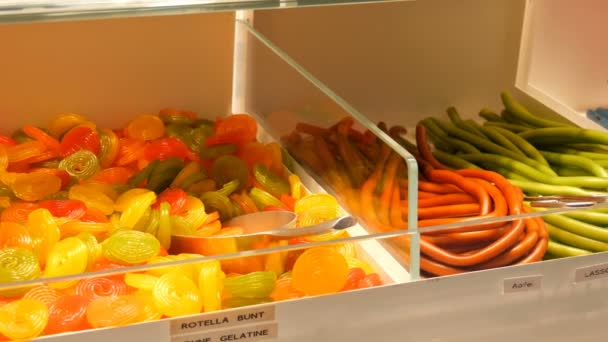 在一家食品市场商店的柜台上, 各种五颜六色的果冻糖果, 德国糖果的名字 — 图库视频影像