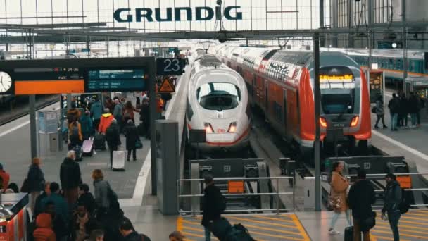 Múnich, Alemania - 2 de diciembre de 2018: Los trenes modernos y de alta velocidad van por buen camino. Los pasajeros pasan a lo largo de la plataforma en la estación de tren — Vídeo de stock