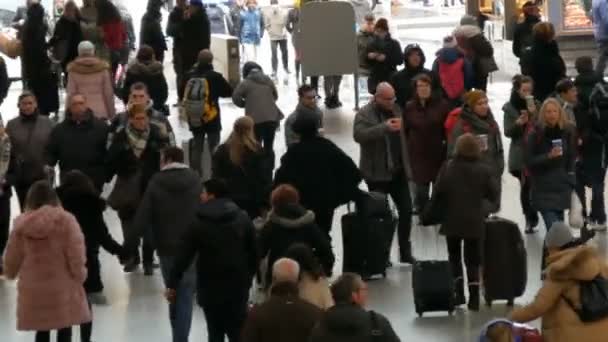 München - 2. Dezember 2018: Blick von oben auf Reisende mit Koffern, Rucksäcken und Taschen, die auf dem Bahnhof unterwegs sind — Stockvideo