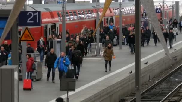 ミュンヘン ドイツ 2018 の群衆の中から抜け出す主要鉄道駅でモダンな赤い電車 — ストック動画