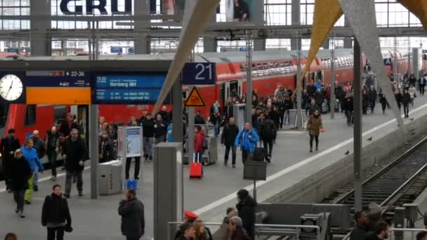 Мюнхен, Германия - 2 декабря 2018 года: Толпа людей выходит из современного красного поезда на центральном железнодорожном вокзале — стоковое видео