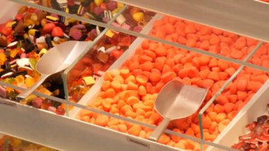 Karışık renkli jöle şekerler bir gıda pazarı mağazasında Alman şeker adları, sayaçta şeker ağırlığında olan kürek