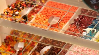 Bir gıda market mağaza sayaçta çeşitli renkli jöle şekerler. Alman şeker adları. şeker ağırlığında olan kürek