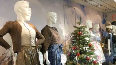 Güzel çeşitli kadın üzerinde dirndl ve mens şortlarla Ulusal Bavyera kostümleri pencere alışveriş