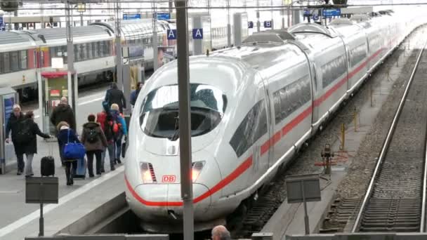 München, Tyskland - 2 December 2018: Höghastighetståg och moderna tåg står på spår. Passagerarna passera längs plattformen vid järnvägsstationen — Stockvideo