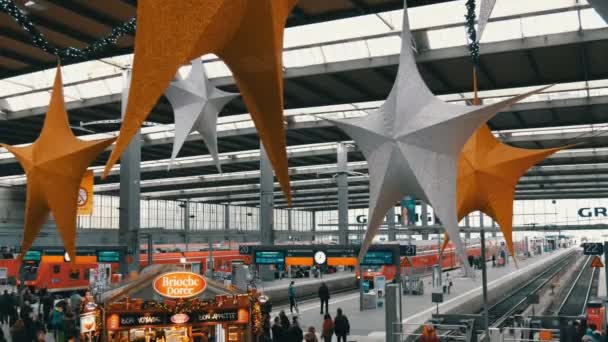 München, Duitsland - December 2, 2018: Treinstation voor Kerstmis. Prachtig ingericht voor Kerstmis station, waar mensen overvol zijn. Grote goud en zilver kerst sterren op plafond bovenaanzicht — Stockvideo