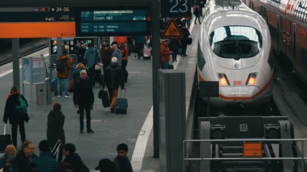 Мюнхен, Германия - 2 декабря 2018: Высокоскоростной и современный поезд стоит на пути. Пассажиры проходят вдоль платформы на железнодорожном вокзале — стоковое видео