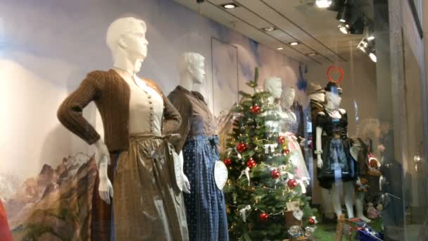 Belas várias mulheres trajes bávaros nacionais dirndl e mens lederhosen na vitrine da loja — Vídeo de Stock