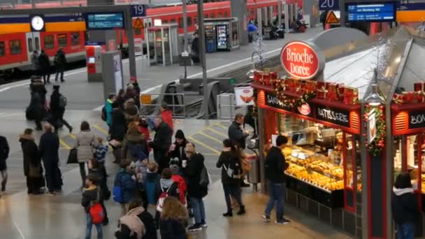 Мюнхен, Германия - 2 декабря 2018 года: Вид сверху на проходящих туристов и пассажиров с чемоданами мимо ларьков с фаст-фудом — стоковое видео