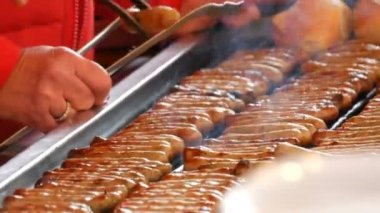 Kadınlar çok lezzetli taze Alman sosis ızgara. Nürnberg sosis taze çörek yakınındaki çok sayıda Noel gıda piyasada hazır mısın
